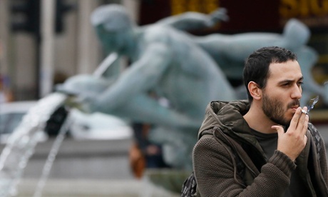 A man smoking near the fountains in Trafalgar Square in London.