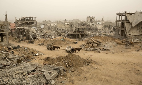 Palestinians ride donkey carts during a sandstorm on February 11, 2015 next to buildings destroyed during last year's 50-day war between Israel and Hamas-led militants, in Gaza City's al-Shejaiya neighborhood.