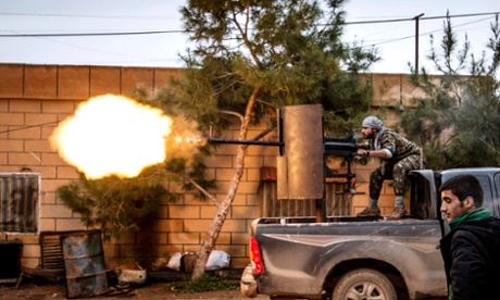 A fighter of the Kurdish People's Protection Units (YPG) fires an anti-aircraft weapon from Tel Tawil village in the direction of Isis fighters.
