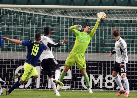 Legia Warszaw’s goalkeeper Dusan Kuciak fails to make the save as Arkadiusz Milik scores for Ajax.
