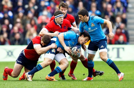 Luca Morisi is checked by the Scotland players.