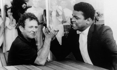 Novelist Norman Mailer arm wrestles with heavyweight champion Muhammad Ali 