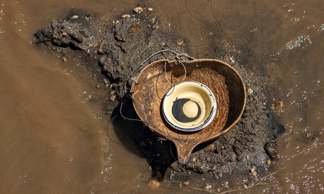 A bowl holding small flakes of gold 