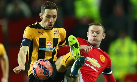 It's a battle as Cambridge's Tom Champion fights with Wayne Rooney for the ball.