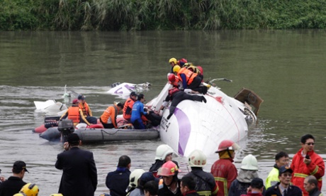 Rescuers pull a passenger out of the TransAsia Airways plane which crash landed in a river, in New Taipei City, February 4, 2015. At least two people killed after a TransAsia Airways plane carrying 58 people crash landed in Taipei River, government said. REUTERS/Pichi Chuang