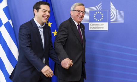 Greek PM Alexis Tsipras and European commission president Jean-Claude Juncker walk hand in hand upon Tsipras's arrival at the EC HQ in Brussels on Feburary 4 2015.