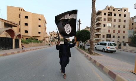 A member of the Islamic State waves a flag in Raqqa, Syria
