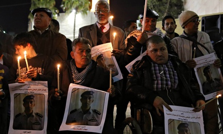 Palestinians hold candles and photos of Jordanian pilot Moaz al-Kasasba
