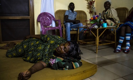 Angele lies on a mattress in the living room