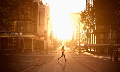 a woman runs through the city at sunrise