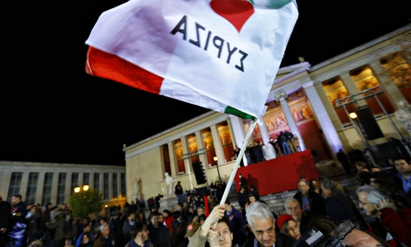A member of the crowd waves a Syriza flag in Athens, Greece