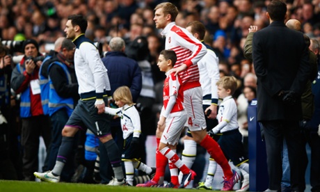Hugo Lloris of Tottenham Hotspur walks out with Per Mertesacker of Arsenal
