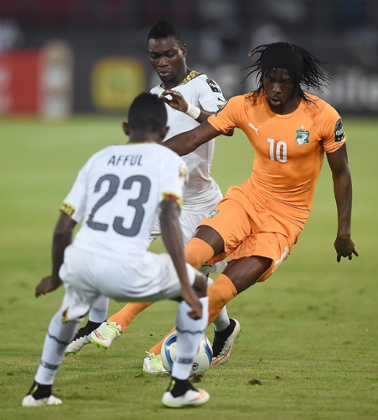 Gervinho challenges Ghana's defender Harrison Afful .