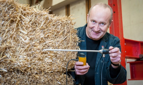 Prof Pete Walker from the University of Bath takes a moisture reading from straw bales used in the construction of the houses.