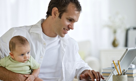 Man looking at internet with baby