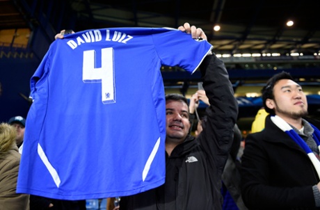A Chelsea fan holds up a David Luiz shirt.