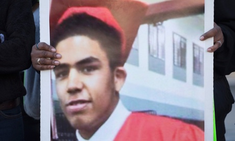 A family member holds a picture of Tony Robinson during a  protest outside of the City Hall building on 9 March.