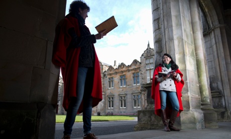 University students wearing traditional capes, reading books (Scotland, UK).