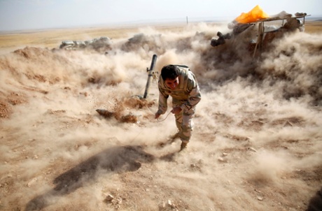 A Kurdish Peshmerga fighter launches mortar shells towards Zummar, controlled by Isis.