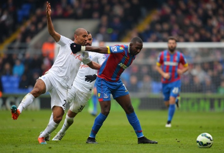 Yannick Bolasie holds off QPR's Karl Henry.