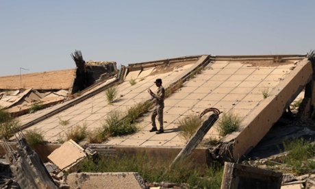 An Iraqi soldier takes photos of the demolished tomb of former Iraqi president, Saddam Hussein, in Tikrit, Iraq