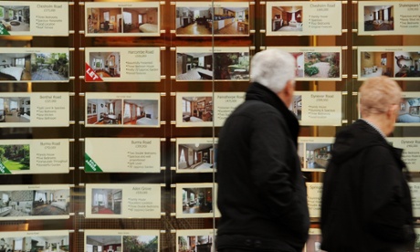 Older couple walking past an estate agents window