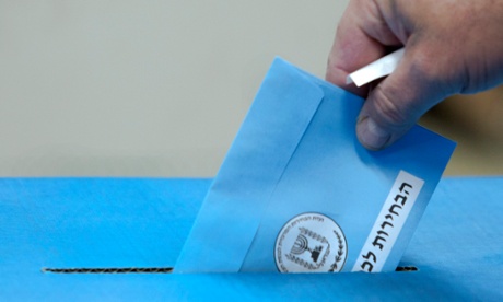An Israeli drops his ballot into the ballot box as he votes in the general election in Tel Aviv.