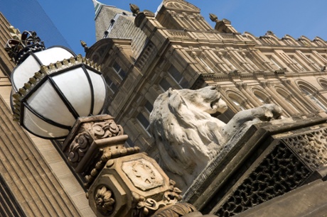 A carved lion and ornate lamp outside Leeds Town Hall.