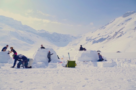 Families building igloos in the sunlight at Adelboden, Switzerland.