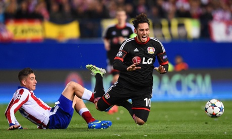 Jose Gimenez of Atletico Madrid brings down Hakan Calhanoglu of Bayer Leverkusen.