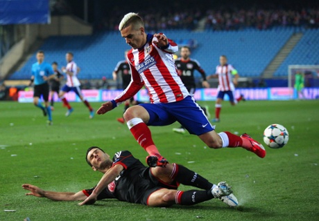 Antoine Griezmann of Atlético Madrid leaps over the challenge from Emir Spahic of Bayer Leverkusen during the Champions League match at Vicente Calderon Stadium.