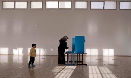 An Israeli Arab stands behind a voting booth before casting. With results so tight, the new government in Israel could take many forms.