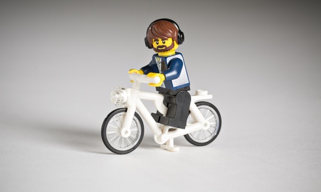 Lego figure with beard and headphones on a bike
