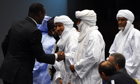 Malian Foreign Minister Abdoulaye Diop (L) shakes hands with representatives of Malian armed rebel groups at the end of a peace agreement ceremony as part of mediation talks between Bamako and some northern militants, on March 1, 2015 in the Algerian capital Algiers. The deal, hammered out in eight months of tough negotiations in neighbouring Algeria, provides for the transfer of a raft of powers from Bamako to the north, an area the size of Texas that the rebels refer to as 