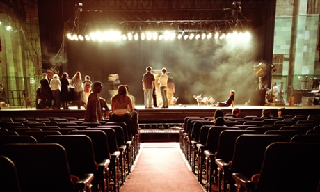 People on stage in empty theatre