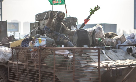A soldier of the 95th Brigade, deployed to protect Donetsk airport, waves from his armoured car as it drive through Kiev 