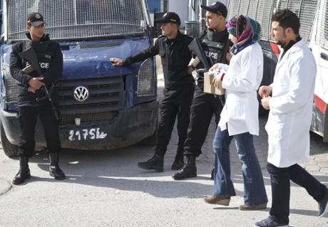 Tunisian police officers, stand guard at the Charles Nicolle hospital in Tunis