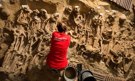 An archaeologists at works at the site of eight mass graves found under a store in Paris