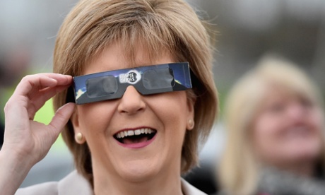 First Minister Nicola Sturgeon uses protective glasses to look into the sky at a partial solar eclipse in Glasgow, Scotland.