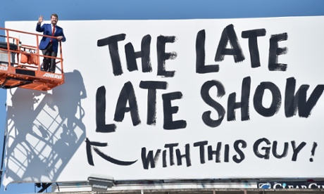 James Corden poses with a billboard for the Late Late Show in Los Angeles.