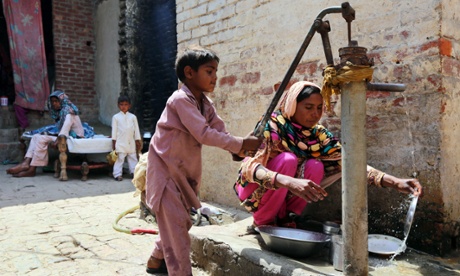 Boy pumping water outside a house in Lahore, Pakistan.