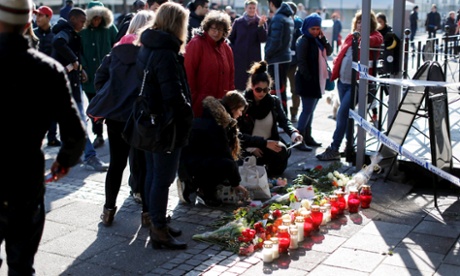 Members of the public leave floral tributes at the scene of the shooting in Gothenburg.