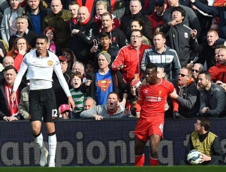 Mario Balotelli is held back by supporters after a clash with Chris Smalling.