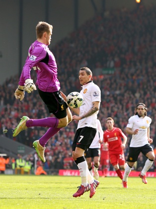 Angel di Maria and Simon Mignolet challenge for the ball.