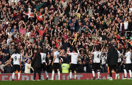 Manchester United players celebrate their victory with their supporters.