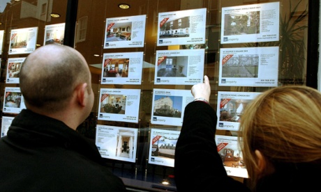 Couple looking in estate agents window