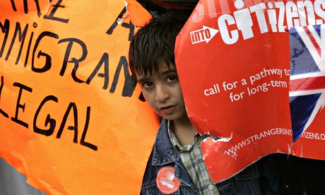 A child peers out during the migrant's day march for immigrant rights in Trafalgar Square