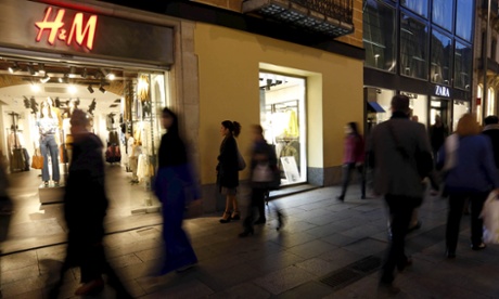 People walk past H&M and Zara stores in central Barcelona.