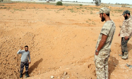 Libya Dawn fighters check a cater left by an air raid in the Tarhouna area on Monday. Human rights groups have not been able to confirm any deaths.