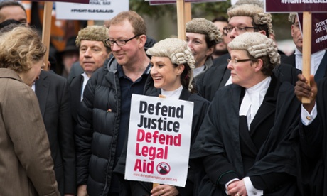 lawyers, some in wigs, protest, including one holding a placard reading 